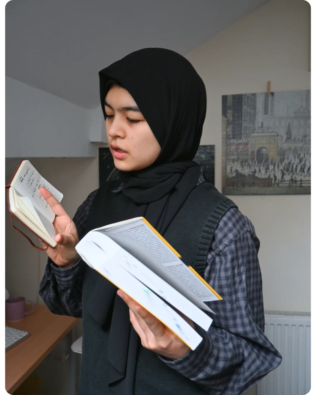 Zubiya sensei reading from a notebook and textbook